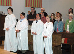 Altar servers Thompson Manuszak, left, Steve Mailloux, P.J. Sylvester and Maddie Lindley listen to Bishop Christopher J. Coyne during the 13th annual SPRED Mass on May 1 at St. Pius X Church in Indianapolis. The altar servers are members of St. Pius X Parish. (Photo by Mike Krokos)