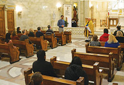 Father Lawrence Richardt looks on as Paul Giesting, left, thanks those who came to the archdiocese’s first Gold Mass for Scientists, which he helped coordinate, in the chapel of SS. Peter and Paul Cathedral in Indianapolis on Nov. 15, the feast of St. Albert the Great, patron of scientists. (Photo by Natalie Hoefer)